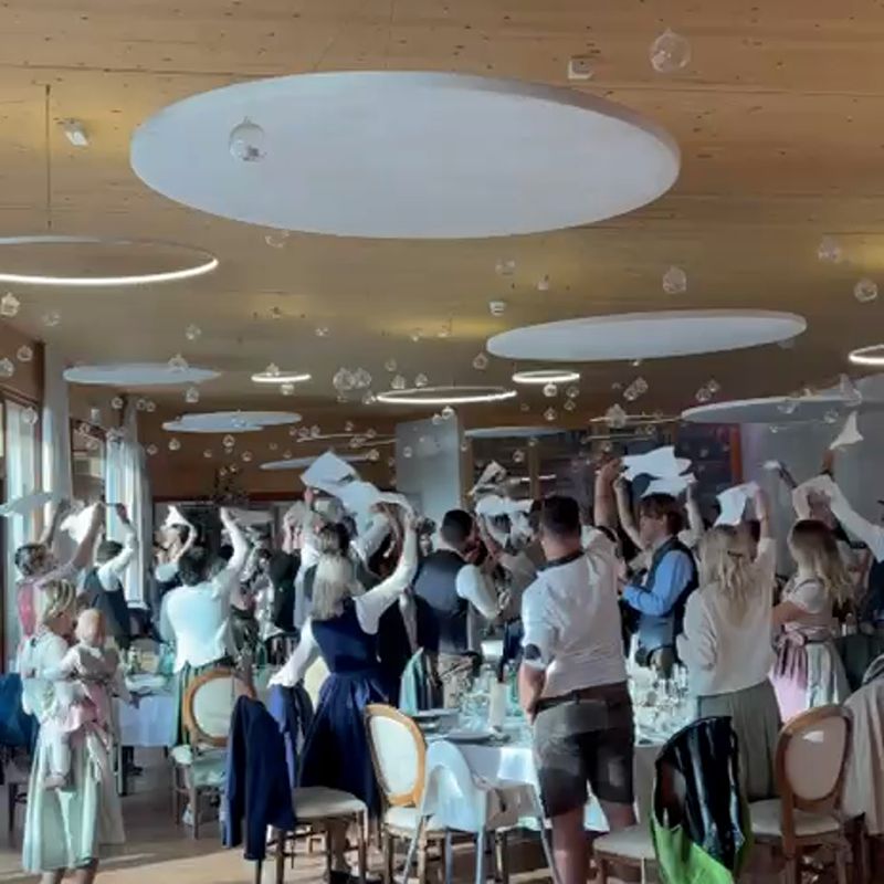 Hochzeitsgäste schwenken im Holzsaal die Servietten